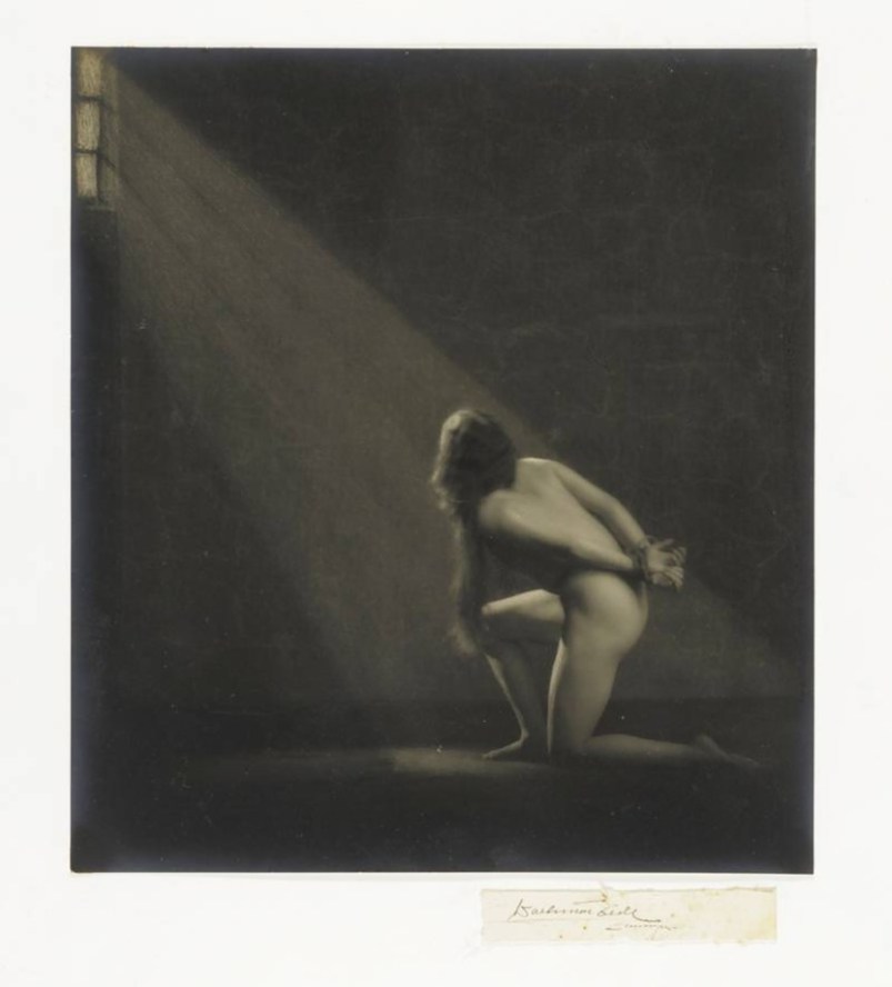 Waldemar Eide - Nude woman on her knees with her hands tied behind her back, ca. 1919