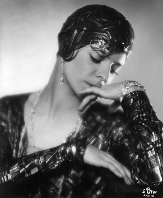 Madame d'Ora -Dancer Alice Nikitinamit portrait with a brown felt toque covered with brown glycerinized rooster feathers curled around the head._e